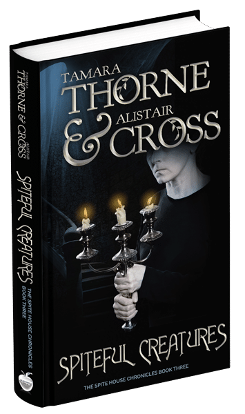 3D book cover for Spiteful Creatures by Tamara Thorne & Alistair Cross: An older woman dressed in black holding a candelabra with three lit candles while standing at the bottom of a staircase.